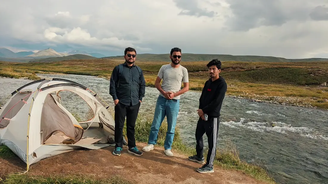 Tents pitched by a river on the high plains